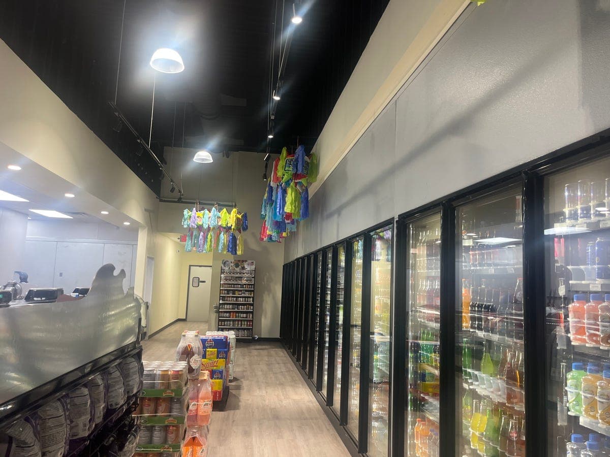 Checkout area with beverage coolers and piñatas at Los Portales