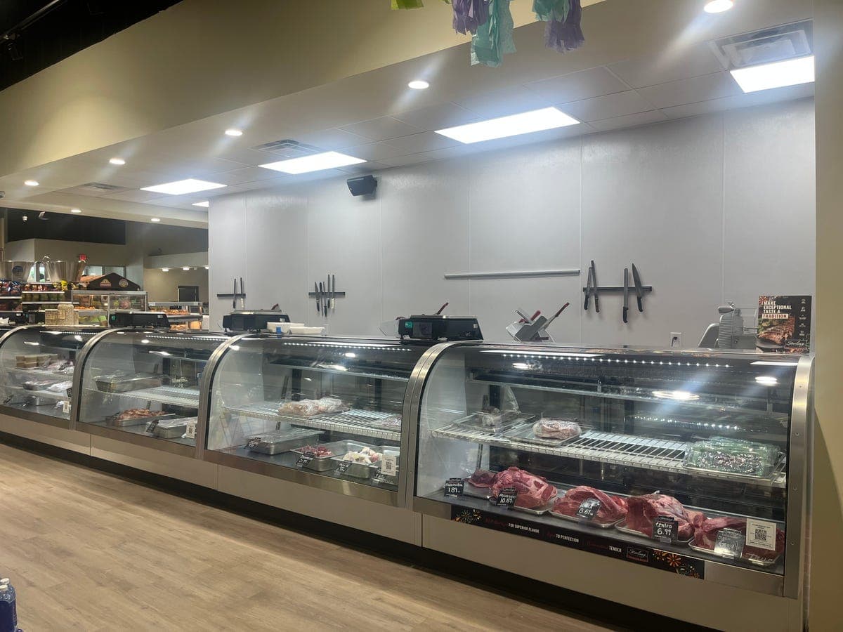 Carnicería butcher service counter with meats at Los Portales