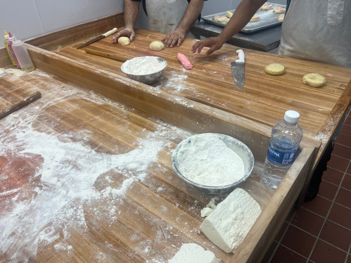 Bakery workers shaping conchas dough with pink topping at Los Portales