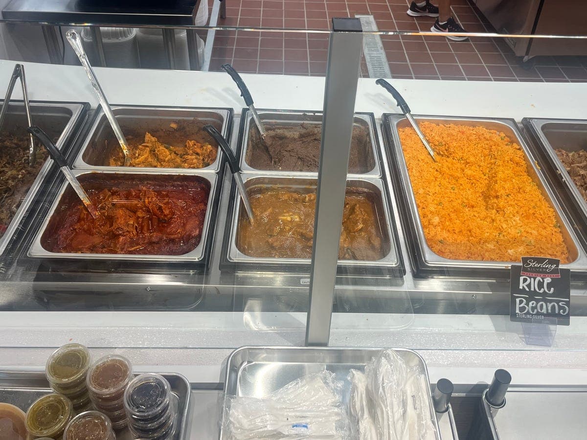 Steam table with rice, beans, and meats in sauce — catering at Los Portales