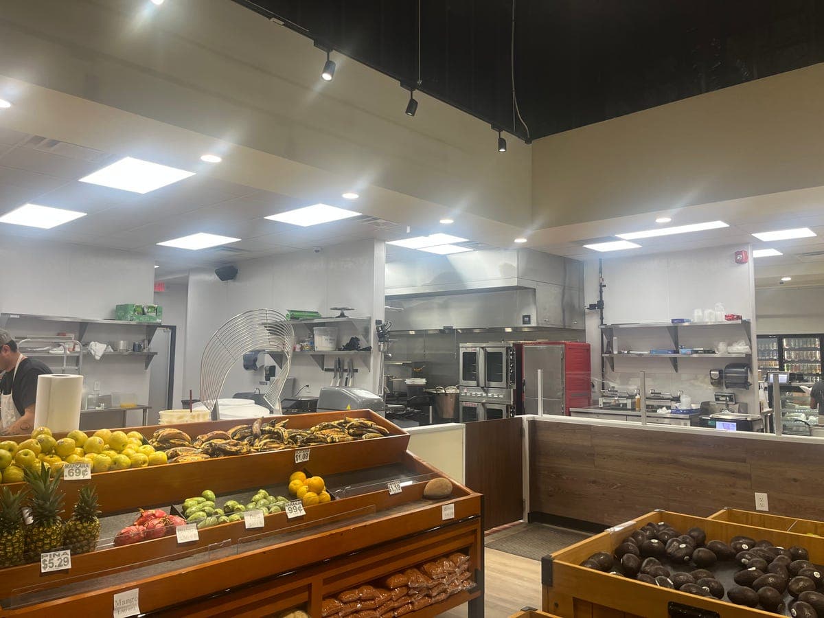 Fruits — pineapples, mangoes, plantains with kitchen visible at Los Portales